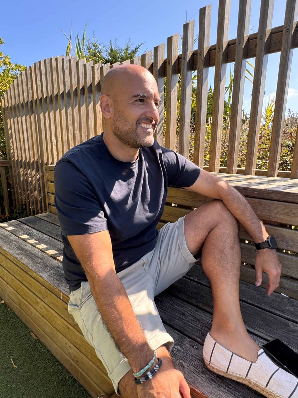 Andrés Molina sentado al aire libre, en un banco de madera